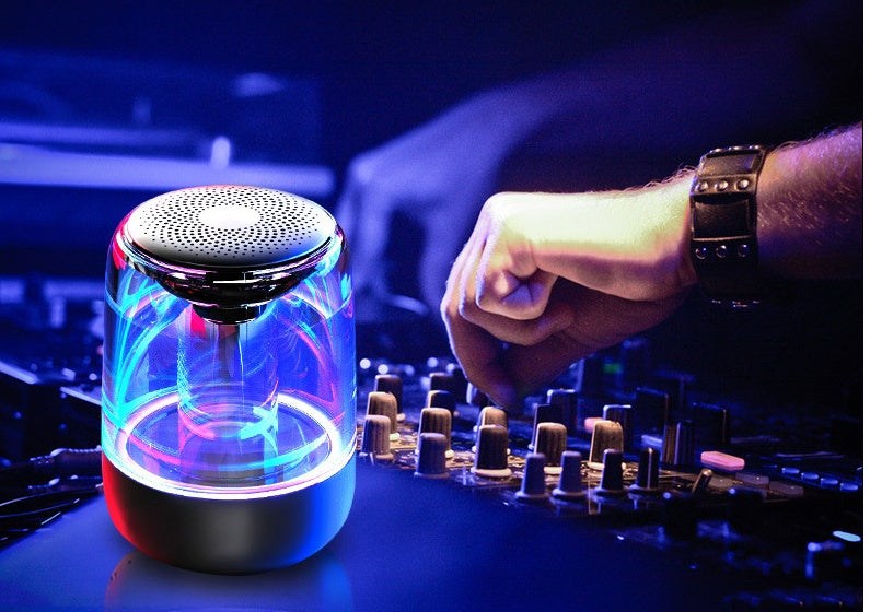 Portable Bluetooth speaker with powerful bass and variable color LED light, compact wireless design for outdoor use.